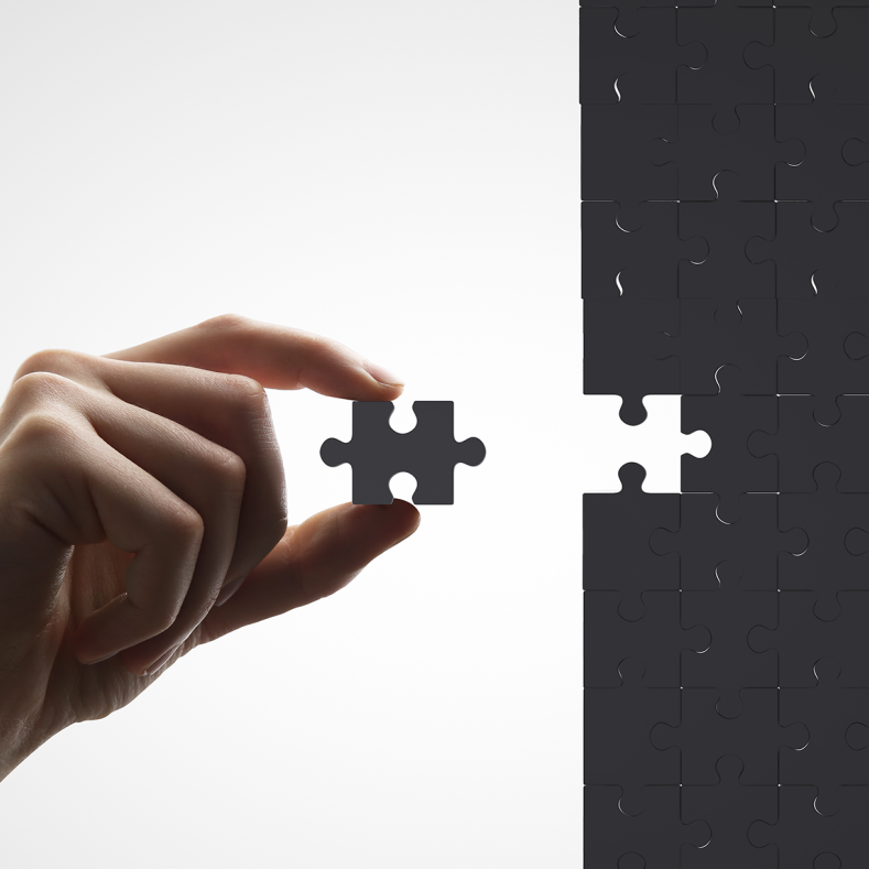 Hand inserts missing piece of the puzzle